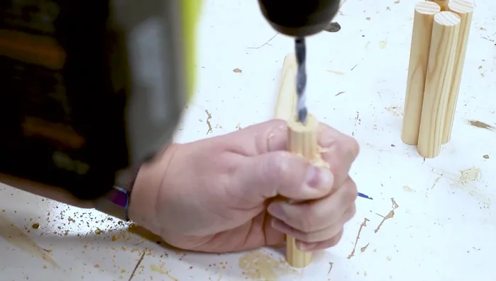 Cut dowels into peg lengths. Drill pilot and larger holes to fit hanger bolts. Arrange pegs to fit containers, secure with wing nuts.