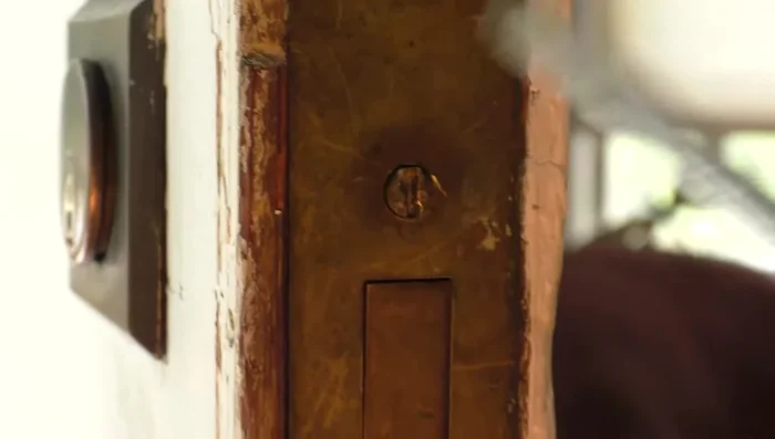 Remove the key cylinder by loosening the set screw and unscrewing the cylinder.