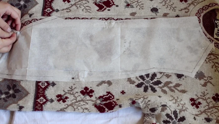 Pin the pattern to the front of the cardigan. Because of the thickness and buttons, pin the pattern to one side, cut, then flip and use the cut piece as a template for the other side.