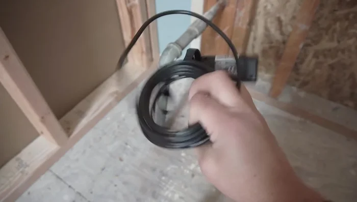 Locate the floor joists using a stud finder to determine the best placement for the new pipe route, ensuring it avoids structural compromises.