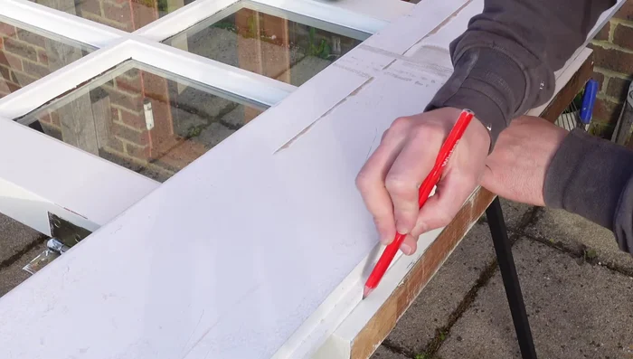 Secure a straight edge along the cutting line using clamps.