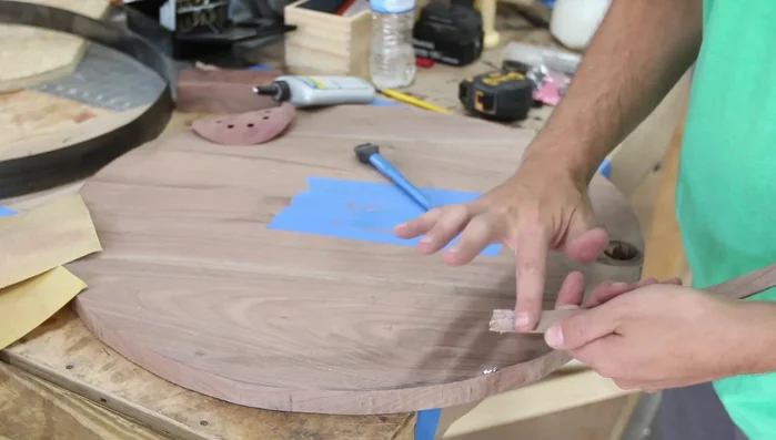 Sand and refine the walnut circle: Smooth the edges using a bandsaw and random orbit sander. Apply a chamfer to the edges.