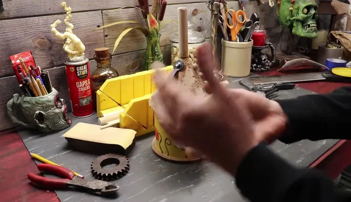 Create and attach the mouth: Cut a mouth shape from a 5-gallon bucket. Attach teeth and gears.