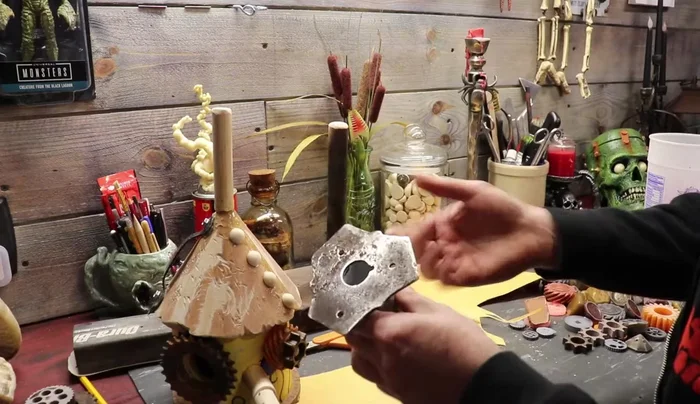 Create the neck and vertebrae: Using an old weed eater blade, create a neck stand. Attach gears as vertebrae.