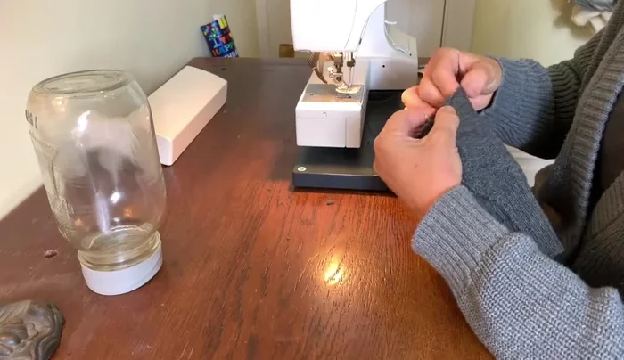 Create pleats at the bottom of the tube and pin them in place. Sew the pleats to secure them.