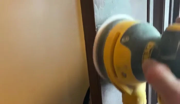 Sand the dried Bondo smooth using an oscillating sander with 220 grit sandpaper, removing almost all of the excess.