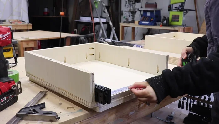 Install the drawers into the compartments, pre-drilling holes for the slides.