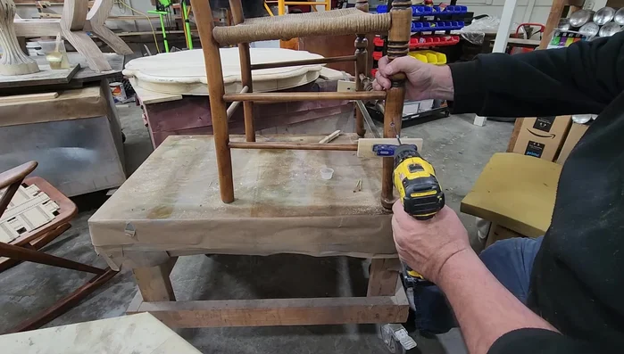 Drill pilot holes into the spindle from the outside of the chair leg to prevent splitting when inserting the screws.