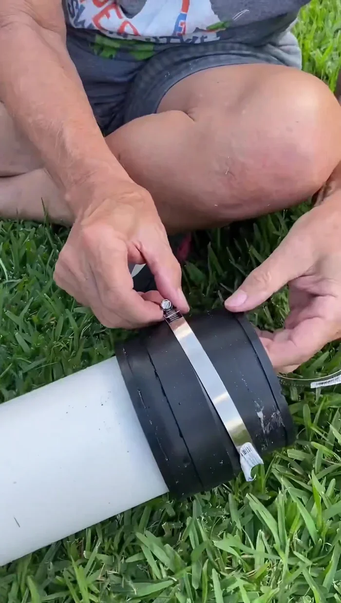 Tighten the hose clamps to secure the connection between the new section and the existing pipe.