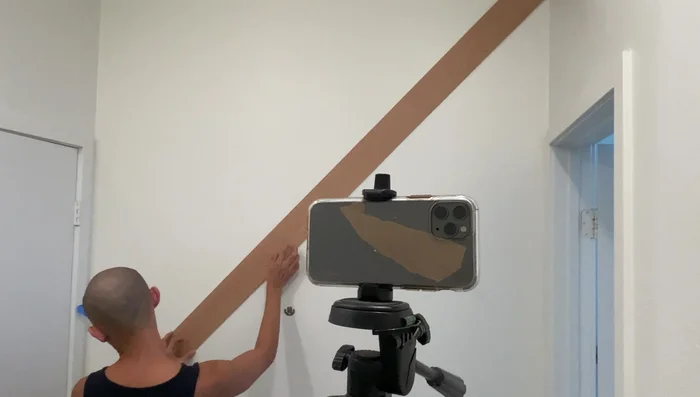 Fill nail holes with spackle and paint the upper wall black, contrasting with the white lower third.