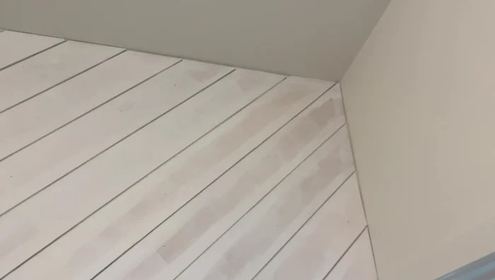 Fill nail holes with spackle and paint the upper wall black, contrasting with the white lower third.