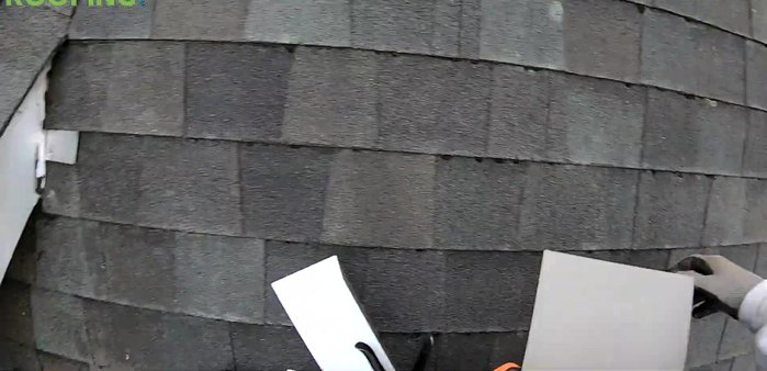 Use a piece of bent flat metal as a wedge to help lift and position the flashing.