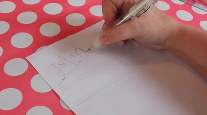 For the menu board (cookie sheet), remove tape from edges, carefully scoring where it meets the paint. Transfer and trace your design, then trace onto the chalkboard with the Sakura Solid Marker Slim.