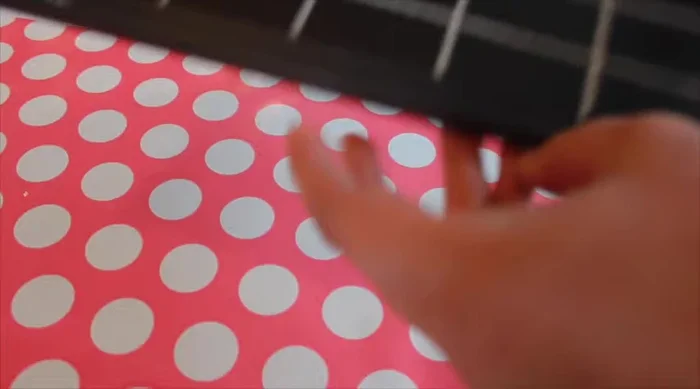Add a ribbon hanger to the cookie sheet by cutting a piece of wired ribbon, hot gluing it in a loop to the back, and tying a bow.