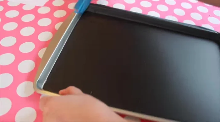 For the menu board (cookie sheet), remove tape from edges, carefully scoring where it meets the paint. Transfer and trace your design, then trace onto the chalkboard with the Sakura Solid Marker Slim.