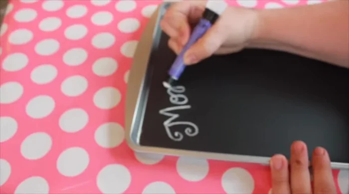 Add a ribbon hanger to the cookie sheet by cutting a piece of wired ribbon, hot gluing it in a loop to the back, and tying a bow.