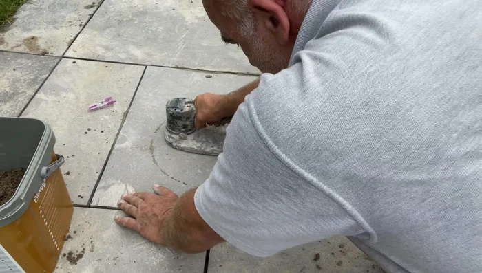 Firmly press the tile into place, using a rubbing motion to ensure good contact with the cement.