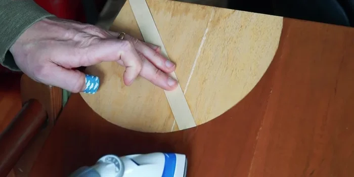 Carefully apply the iron-on veneer strips, using an iron to adhere them to the chair. Avoid burning the chair's finish by ironing from different directions.