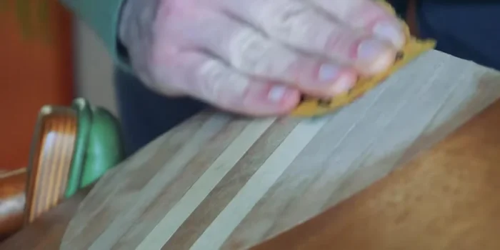 Sand the repaired area to smooth out the surface, starting with coarser grit sandpaper and finishing with finer grit.