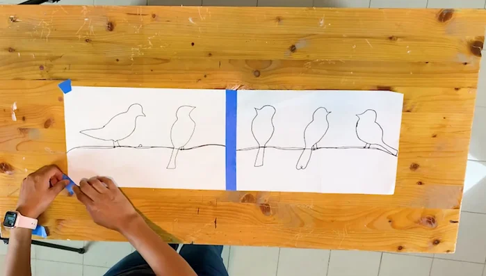 Secure the drawing: Stick the drawing onto your working table using masking tape to prevent it from moving.