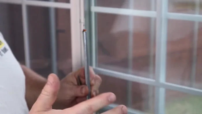 Using the appropriate tool (as shown in the video), insert the new spring from the *outside* of the window frame and turn it clockwise about 10 times to secure it.