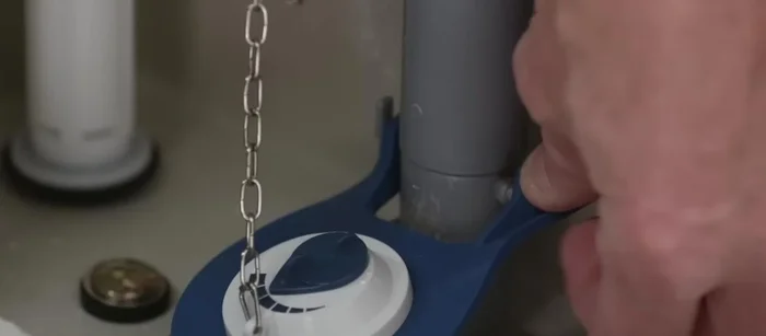 Adjust the chain length as needed, and replace the toilet tank lid.