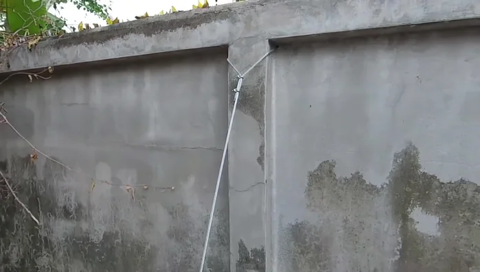 Continue tightening the cable until the wall is straight.