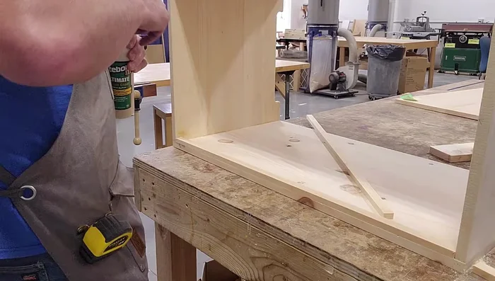 Build the floor (glue and brad nail floorboards onto shelves pre-installed in the interior).
