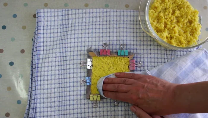 Remove excess water: Press another towel firmly on top of the pulp to absorb excess water. Flip the frame and repeat.