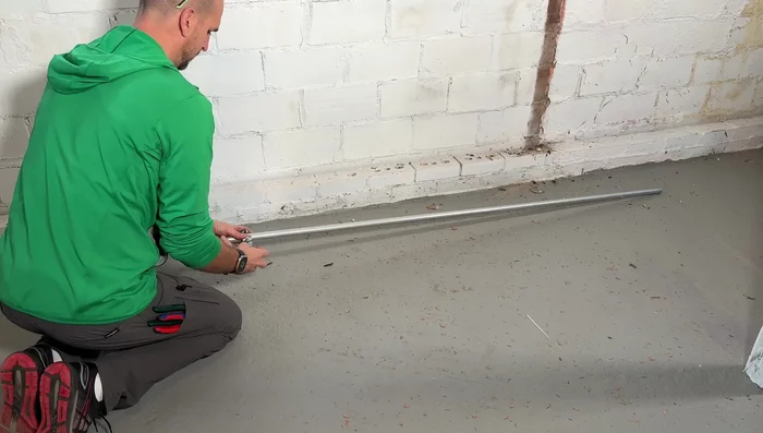 Assemble the conduit run, using adjustable supports to keep it level and away from the wall. Mark and drill mounting holes for the boxes in the brick wall.