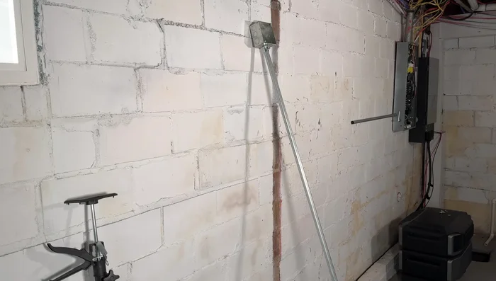 Assemble the conduit run, using adjustable supports to keep it level and away from the wall. Mark and drill mounting holes for the boxes in the brick wall.