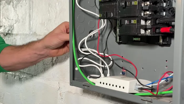 Enlarge the knockout hole on the panel to accommodate the conduit connector. Thread in the connector and secure it using a flathead screwdriver and hammer, or a specialty wrench.