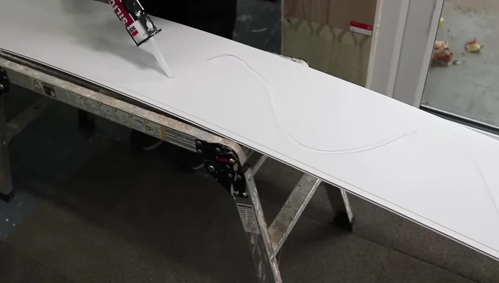 Apply silicone to the back of the panel (side to side if walls are uneven) and add it to the wall, pushing it into the internal trim.