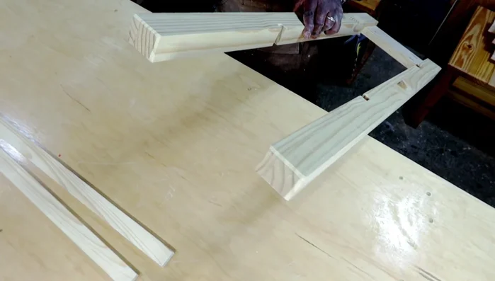 Adding bevels to the bottoms of the legs using a sander.