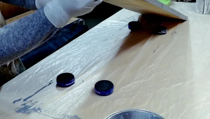 Applying multiple coats of water-based poly acrylic to the tabletop.