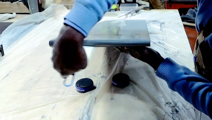 Applying multiple coats of water-based poly acrylic to the tabletop.