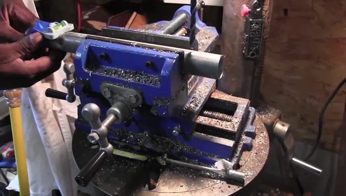 Use a center drill to mark the exact center point of the mounting pipe, ensuring the new holes are centered