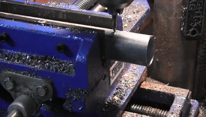 Use a center drill to mark the exact center point of the mounting pipe, ensuring the new holes are centered