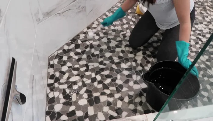 Apply and scrub the cleaner: Apply the cleaning solution to small sections of the shower floor, scrubbing for 3-5 minutes per section with a sturdy brush to ensure thorough cleaning. Keep the area moist to prevent the cleaner from drying.