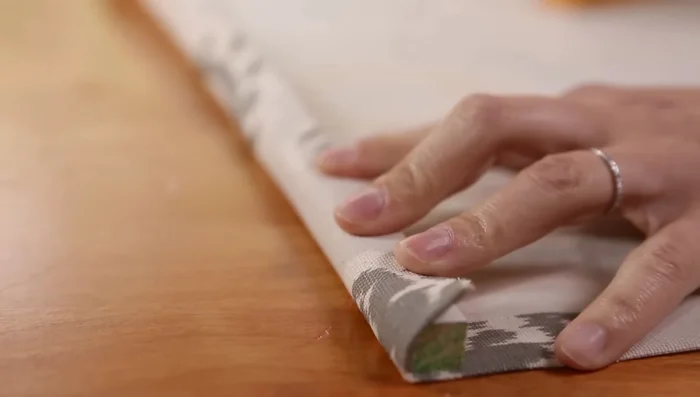 Align unfinished fabric end with dowel and staple in place.