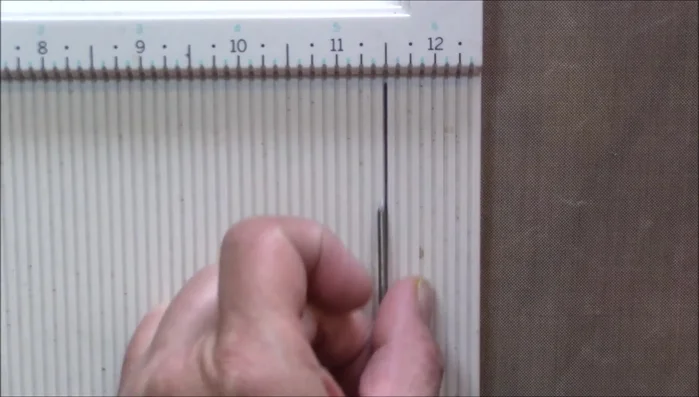 Create holes in the aluminum circles using a scoreboard and needle, ensuring the holes are evenly spaced.