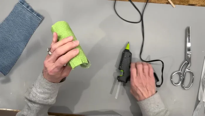 Cut slits in the fabric, glue to the pipe insulation on both ends, and attach felt circles.