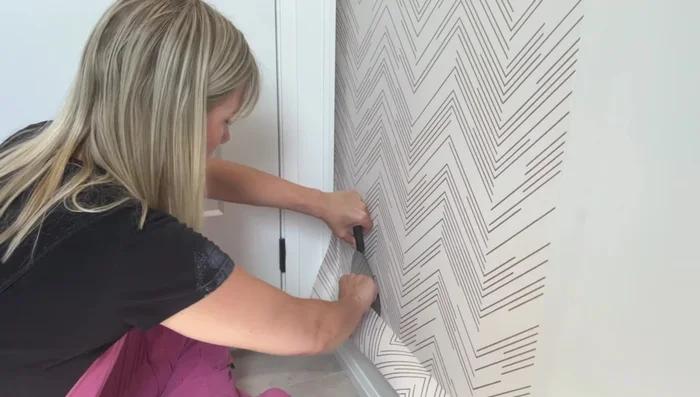 Trim excess: Trim the excess wallpaper at the top and bottom with a sharp exacto knife and straight edge.