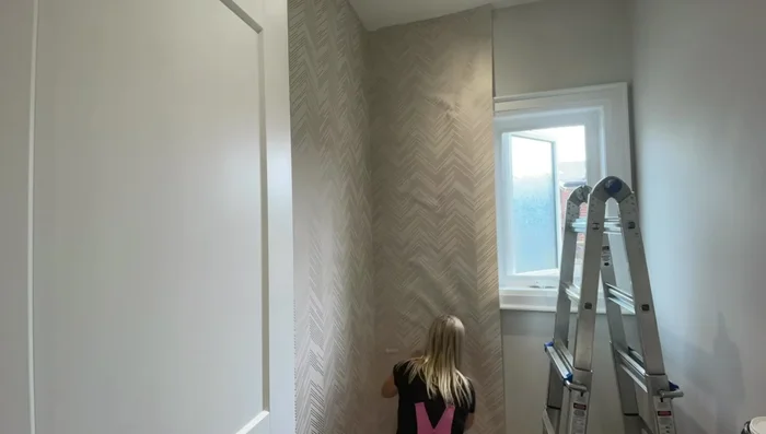 Handle tricky areas: Follow the same principles (paste, hang, smooth, trim) for areas around toilets and sinks, making relief cuts to wrap the wallpaper around fixtures.