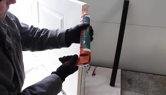 Apply a bead of caulk to the bottom of the door. This will help secure the sweep.