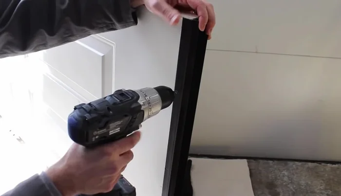 Attach the door sweep to the door using the screws, starting from the center and working outwards.