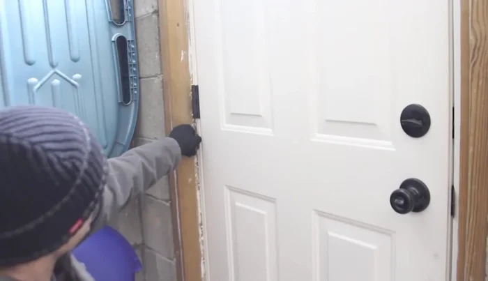 Remove the door from its hinges using a nail set and hammer to remove the hinge pins. Keep the door in the closed position within the door jamb to make this easier.