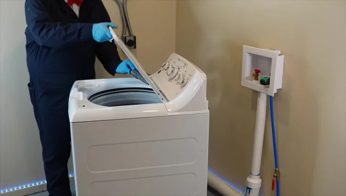 Unplug the washing machine and carefully tilt it back to access the underside.