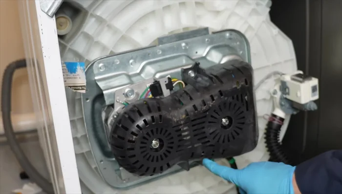 Remove the plastic belt cover using a 38 socket wrench or screwdriver.