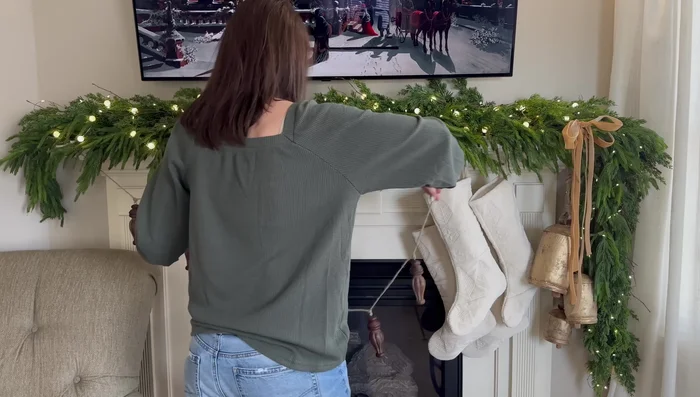 Hang stockings and add a wooden garland and a gold bell garland to the mantel.